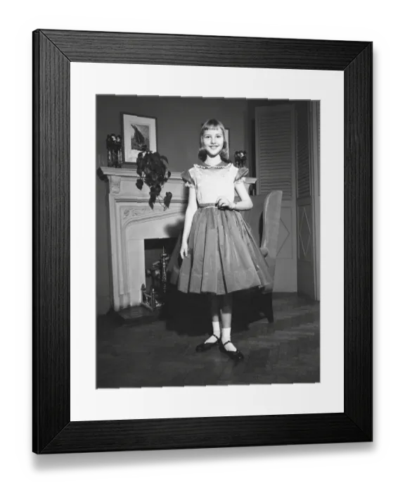 Framed Print : Girl (12-13) posing by fireplace, (B&W), portrait Framed Print : Girl (12-13) posing by fireplace, (B&W), portrait