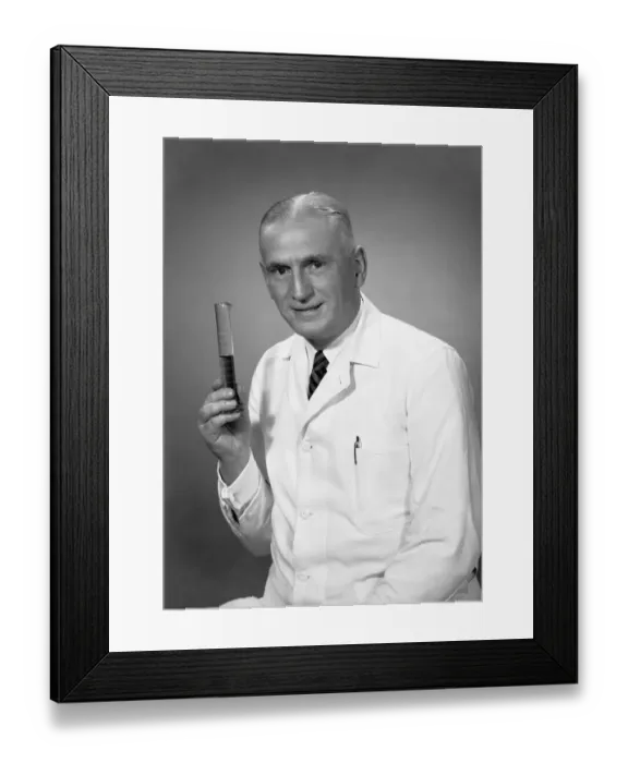 Framed Print : Chemist holding test tube in studio, (B&W), portrait Framed Print : Chemist holding test tube in studio, (B&W), portrait