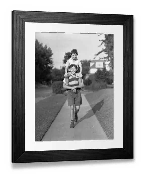Framed Print : Boy (10-11) carrying brother (6-7) on shoulders, (B&W), portrait Framed Print : Boy (10-11) carrying brother (6-7) on shoulders, (B&W), portrait