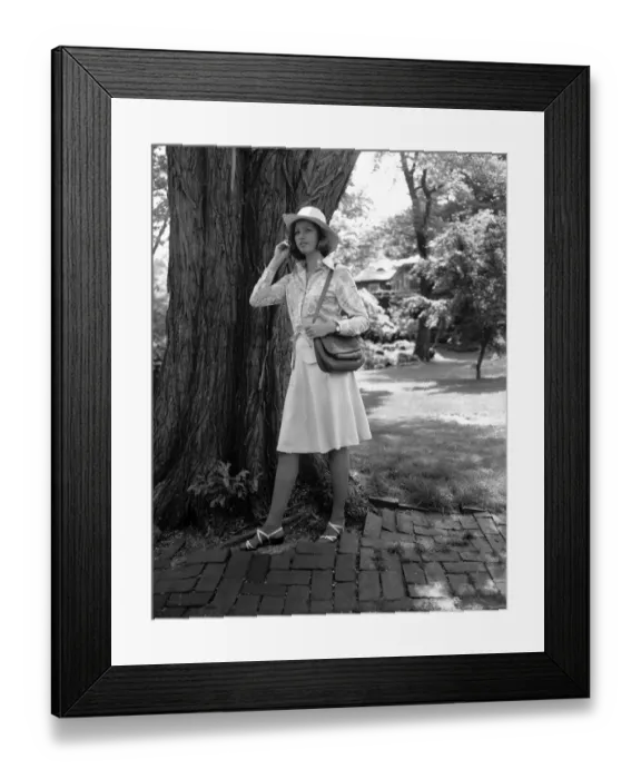 Framed Print : Young woman in hat standing by tree, (B&W) Framed Print : Young woman in hat standing by tree, (B&W)
