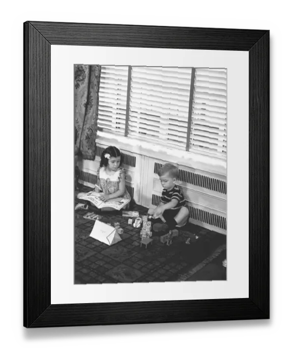 Framed Print : Brother (4-5) and sister (6-7) playing on floor in family room, (B&W) Framed Print : Brother (4-5) and sister (6-7) playing on floor in family room, (B&W)