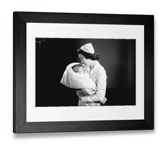 Framed Print : Nurse hugging newborn (0-3 months) wrapped in blanket, (B&W) Framed Print : Nurse hugging newborn (0-3 months) wrapped in blanket, (B&W)