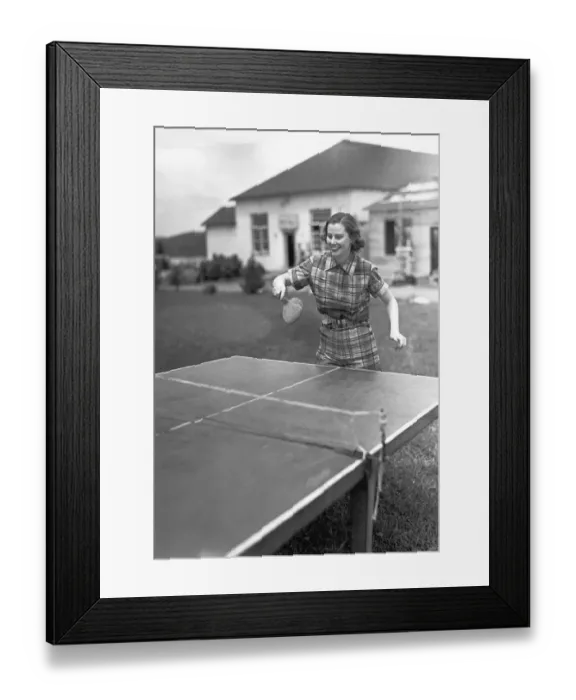 Framed Print : Woman playing table tennis in garden, (B&W) Framed Print : Woman playing table tennis in garden, (B&W)