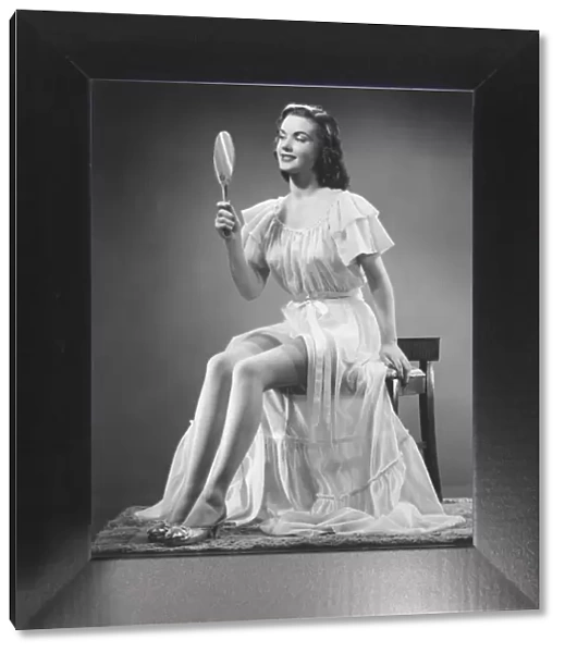 Woman looking at hand mirror (B&W)