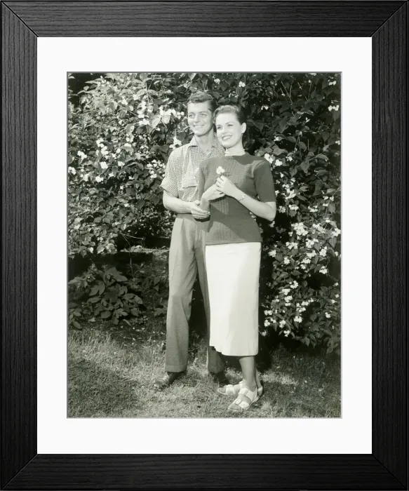 Framed Print : Young couple standing in garden Framed Print : Young couple standing in garden