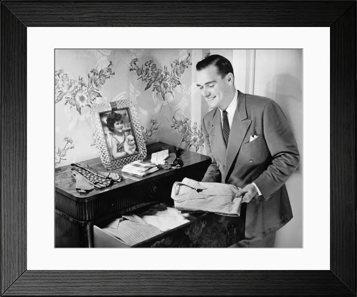 Framed Print : Man taking folded shirt from drawer (B&W) Framed Print : Man taking folded shirt from drawer (B&W)