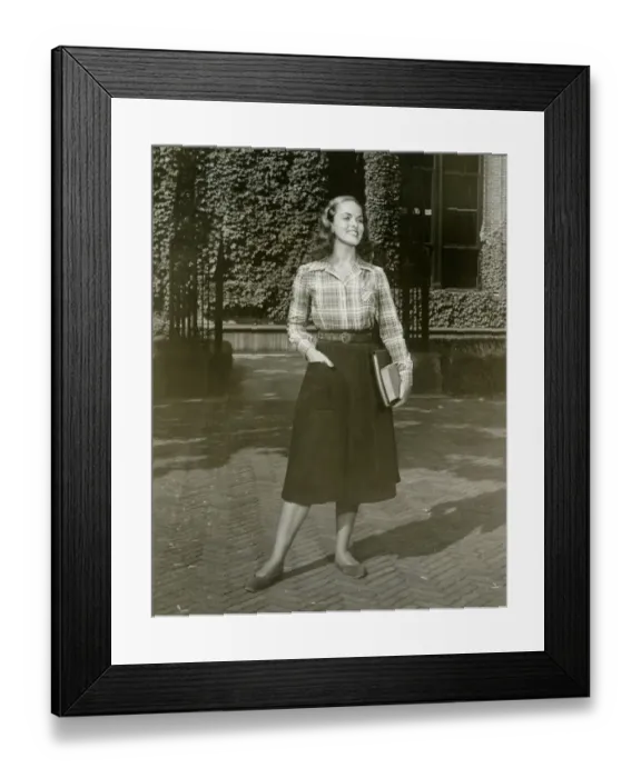 Framed Print : Young woman holding books, standing outdoors Framed Print : Young woman holding books, standing outdoors