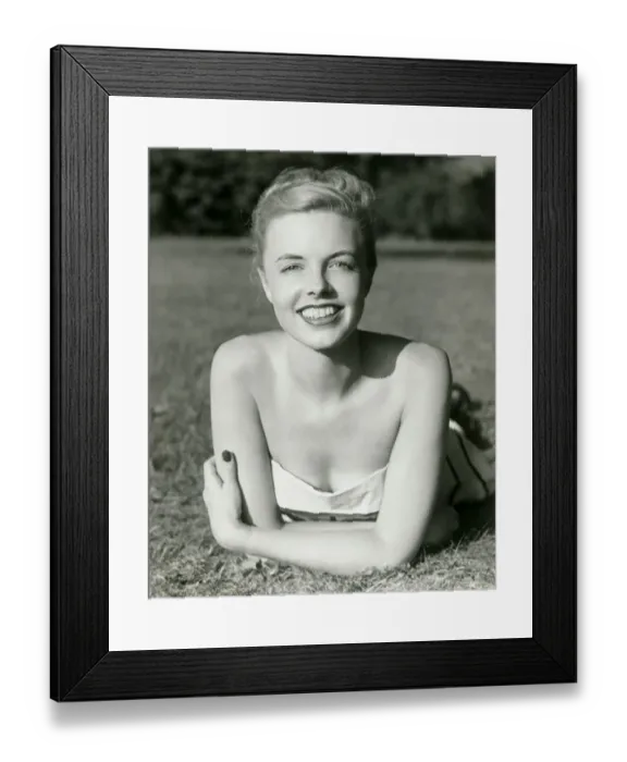 Framed Print : Young woman lying on grass, smiling, portrait