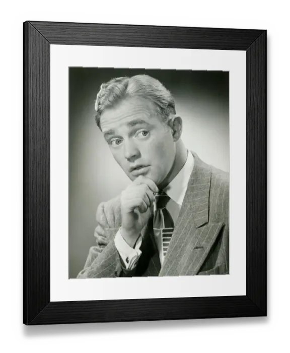 Framed Print : Man with hand on chin, looking away, close-up, studio shot Framed Print : Man with hand on chin, looking away, close-up, studio shot