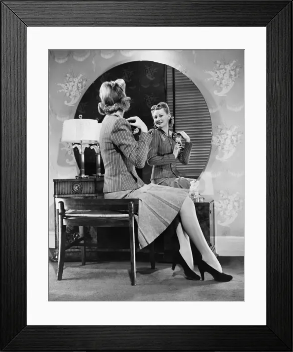 Framed Print : Young woman pinning artificial flowers to jacket in front of mirror (B&W)