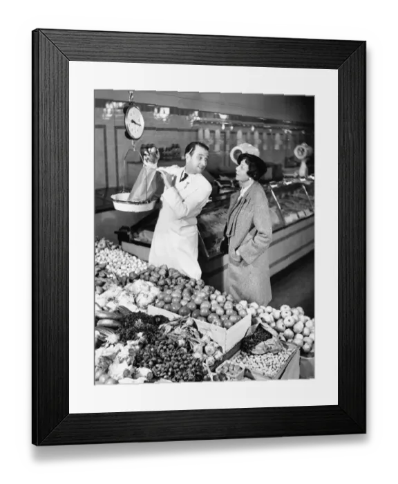Framed Print : Store clerk weighing tomatoes for client (B&W) Framed Print : Store clerk weighing tomatoes for client (B&W)