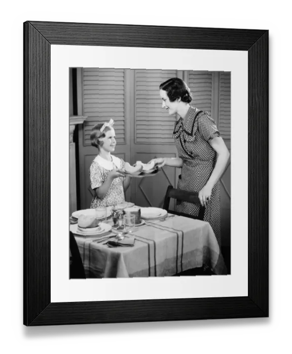 Framed Print : Daughter (8-9) helping mother setting table for breakfast (B&W) Framed Print : Daughter (8-9) helping mother setting table for breakfast (B&W)