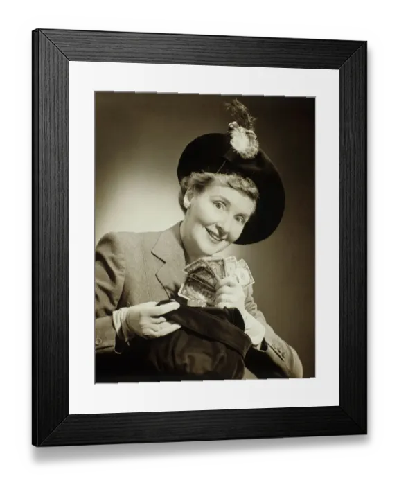 Framed Print : Woman in suit and fashionable hat standing taking money out of bag in studio, (B&W), portrait Framed Print : Woman in suit and fashionable hat standing taking money out of bag in studio, (B&W), portrait