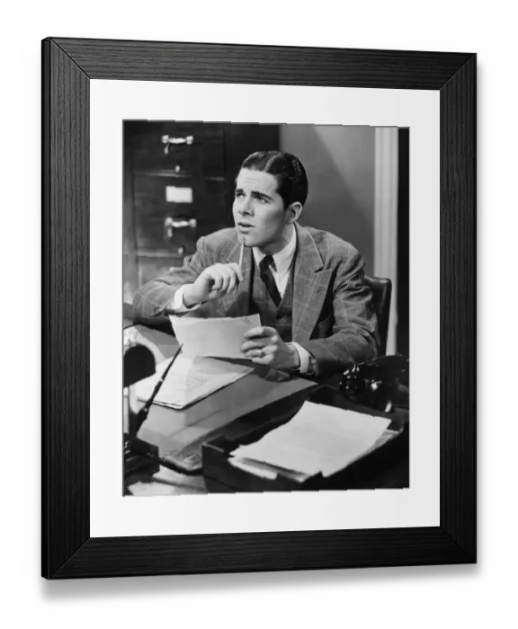 Framed Print : Office worker sitting at desk (B&W) Framed Print : Office worker sitting at desk (B&W)