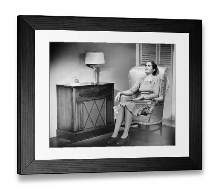 Framed Print : Woman sitting in armchair with book on knees (B&W)