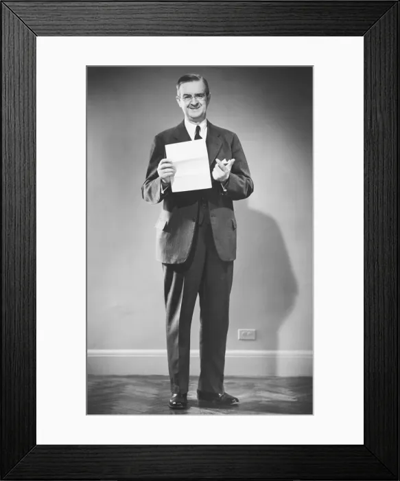 Framed Print : Mature man holding blank sheet of paper posing in studio (B&W), portrait Framed Print : Mature man holding blank sheet of paper posing in studio (B&W), portrait