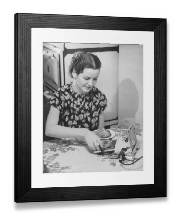 Framed Print : Young woman preparing toasts at kitchen table (B&W) Framed Print : Young woman preparing toasts at kitchen table (B&W)