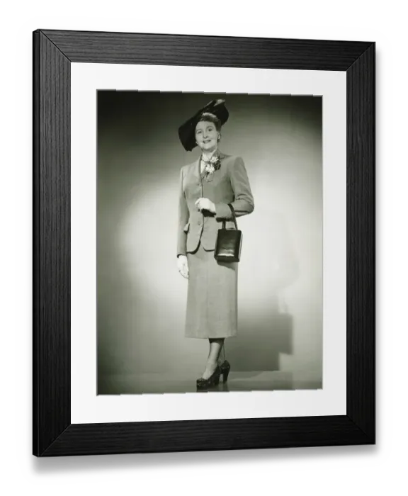 Framed Print : Woman in suit and fashionable hat standing in studio, (B&W) Framed Print : Woman in suit and fashionable hat standing in studio, (B&W)
