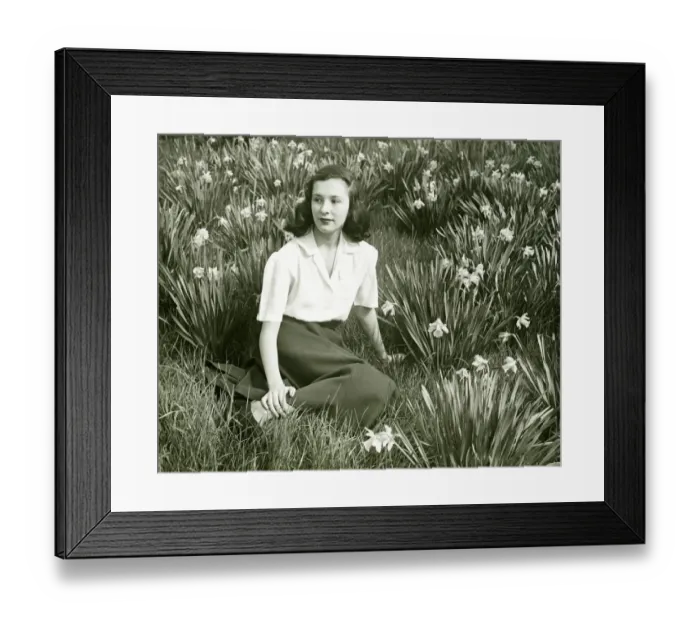 Framed Print : Woman sitting on grass among blooming daffodils, (B&W), (Portrait) Framed Print : Woman sitting on grass among blooming daffodils, (B&W), (Portrait)