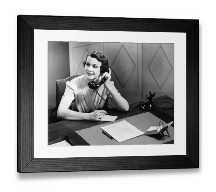 Framed Print : Woman talking on phone at desk (B&W) Framed Print : Woman talking on phone at desk (B&W)