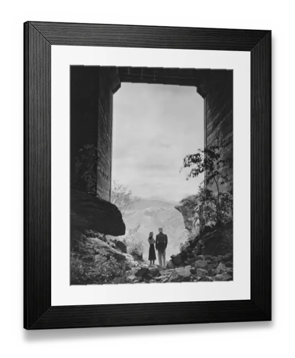 Framed Print : Couple standing in gate, looking at view, (B&W) Framed Print : Couple standing in gate, looking at view, (B&W)