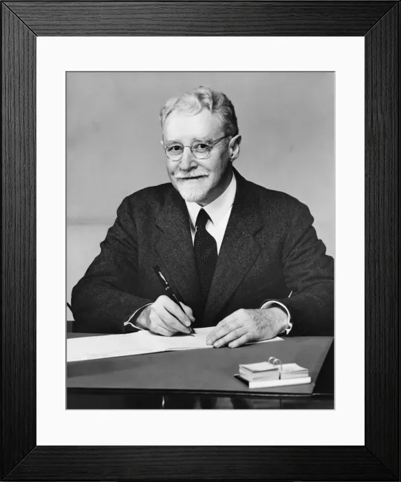 Framed Print : Senior businessman sitting at desk, writing, (B&W) Framed Print : Senior businessman sitting at desk, writing, (B&W)