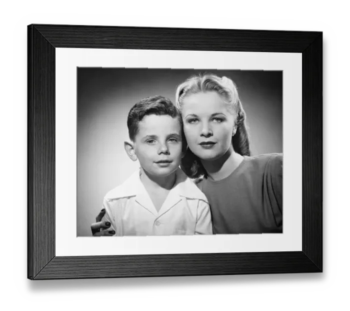 Framed Print : Mother with son (6-7) posing in studio, (B&W), portrait Framed Print : Mother with son (6-7) posing in studio, (B&W), portrait