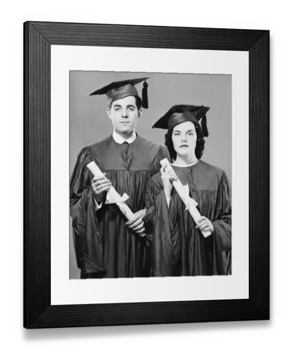 Framed Print : Young couple in graduate dress holding diplomas, posing in studio, (B&W), portrait Framed Print : Young couple in graduate dress holding diplomas, posing in studio, (B&W), portrait