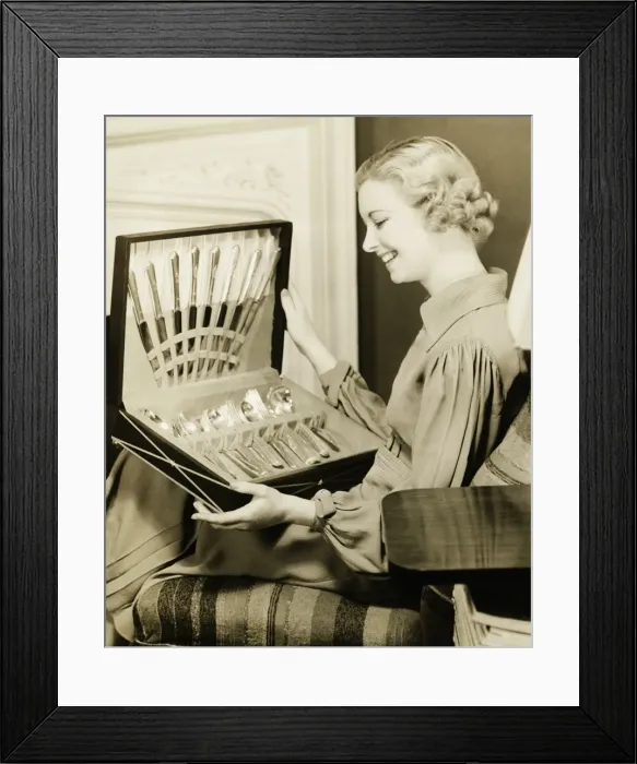 Framed Print : Young woman holding open box with cutlery, smiling, (B&W)