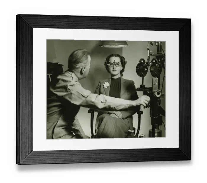 Framed Print : Optician examining patients eyes, (B&W) Framed Print : Optician examining patients eyes, (B&W)