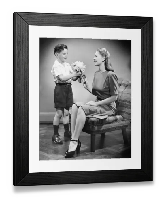 Framed Print : Boy (8-9) giving bunch of flowers to mother (B&W) Framed Print : Boy (8-9) giving bunch of flowers to mother (B&W)