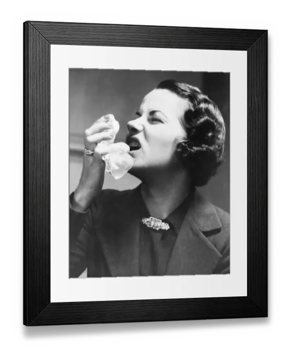 Framed Print : Woman holding tissue, sneezing (B&W) Framed Print : Woman holding tissue, sneezing (B&W)