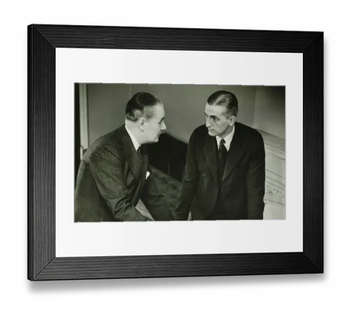 Framed Print : Two businessmen leaning on desk, talking, (B&W) Framed Print : Two businessmen leaning on desk, talking, (B&W)
