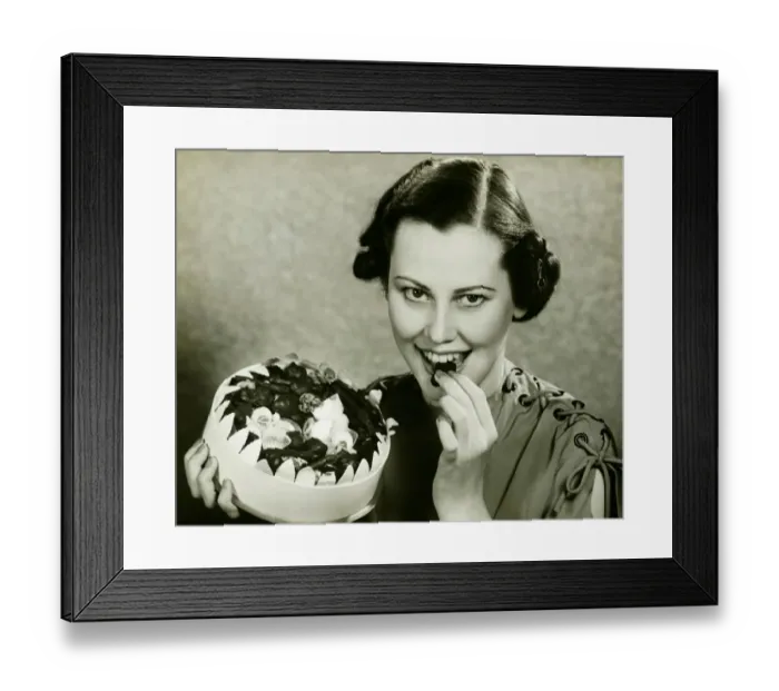 Framed Print : Young woman a chocolate from box, posing, (B&W), portrait Framed Print : Young woman a chocolate from box, posing, (B&W), portrait