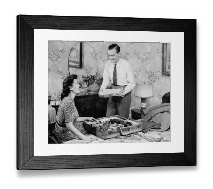 Framed Print : Woman assisting man packing suitcase (B&W) Framed Print : Woman assisting man packing suitcase (B&W)