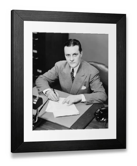 Framed Print : Businessman signing papers at desk in office, (B&W), portrait, elevated view Framed Print : Businessman signing papers at desk in office, (B&W), portrait, elevated view