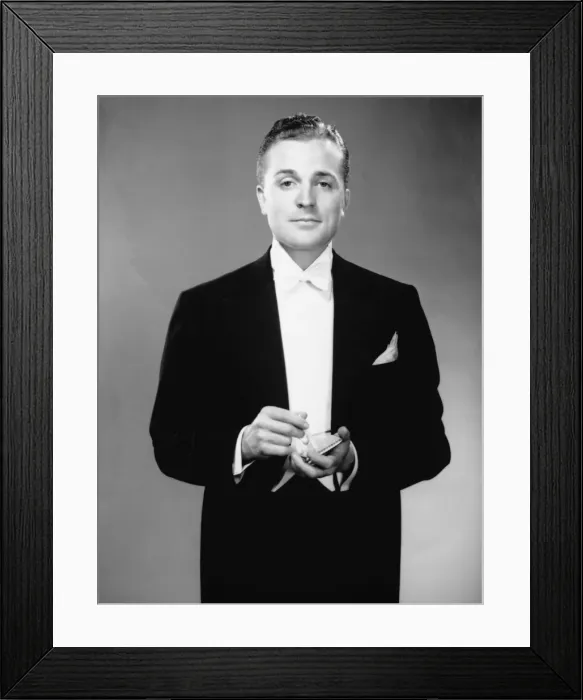 Framed Print : Man in dinner jacket holding cigarette and cigarette case standing in studio, (B&W), portrait Framed Print : Man in dinner jacket holding cigarette and cigarette case standing in studio, (B&W), portrait