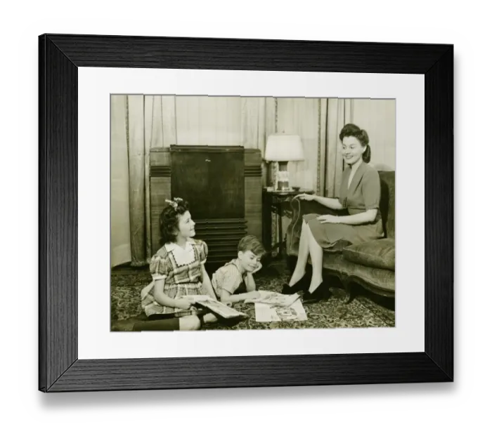 Framed Print : Family at home, children (6-7) (10-11) playing on carpet, mother sitting on sofa, (B&W) Framed Print : Family at home, children (6-7) (10-11) playing on carpet, mother sitting on sofa, (B&W)