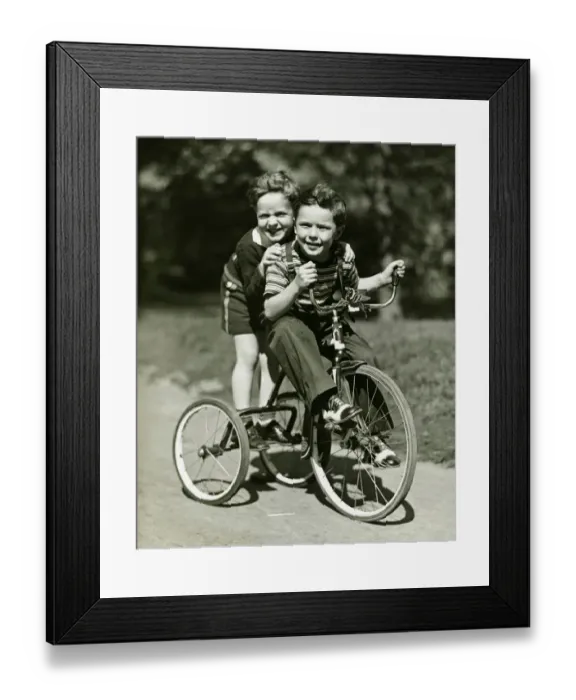 Framed Print : Two young boys (6-7) riding tricycle in park, (B&W), portrait Framed Print : Two young boys (6-7) riding tricycle in park, (B&W), portrait