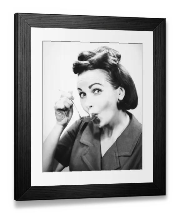 Framed Print : Woman sipping from spoon, (B&W), portrait Framed Print : Woman sipping from spoon, (B&W), portrait