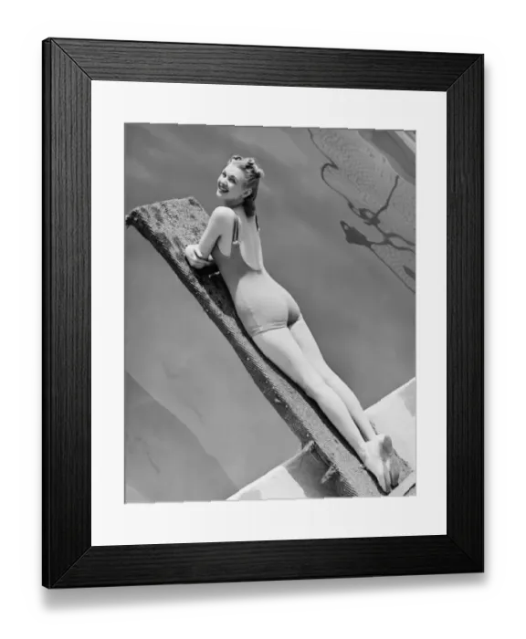 Framed Print : Woman lying on diving board (B&W), elevated view, portrait Framed Print : Woman lying on diving board (B&W), elevated view, portrait