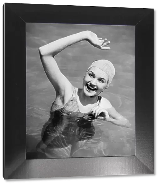 Woman waving in pool (B&W), , elevated view