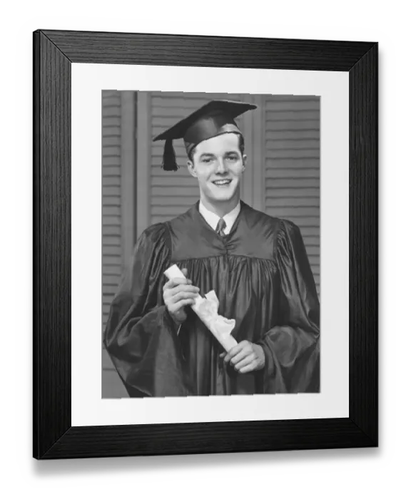 Framed Print : Young male university graduate holding diploma, (B&W), portrait Framed Print : Young male university graduate holding diploma, (B&W), portrait