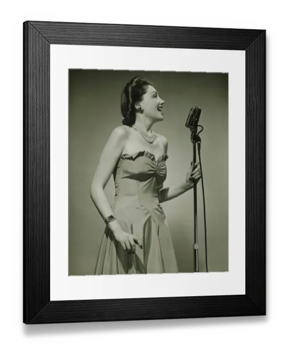 Framed Print : Young woman at microphone, singing, (B&W) Framed Print : Young woman at microphone, singing, (B&W)