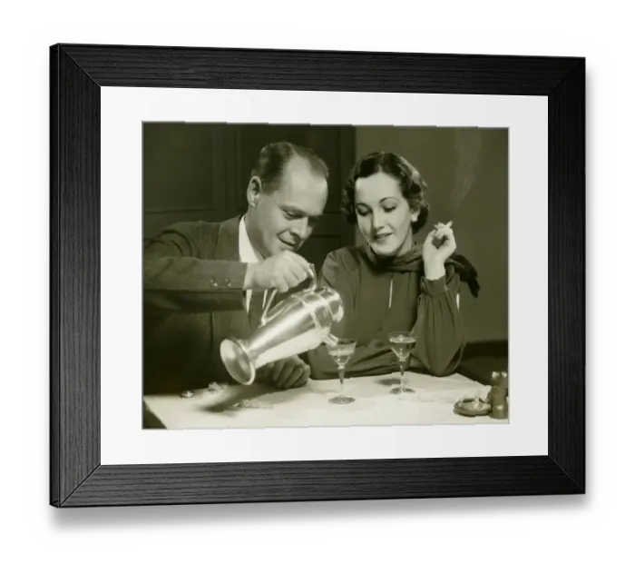Framed Print : Couple sitting at table, man pouring drinks, (B&W) Framed Print : Couple sitting at table, man pouring drinks, (B&W)