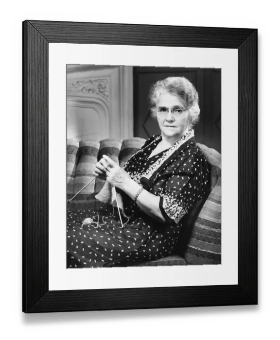 Framed Print : Mature woman knitting in living room (B&W), portrait Framed Print : Mature woman knitting in living room (B&W), portrait