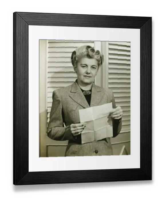 Framed Print : Woman in fashionable suit holding sheet of paper, indoors, (B&W) Framed Print : Woman in fashionable suit holding sheet of paper, indoors, (B&W)