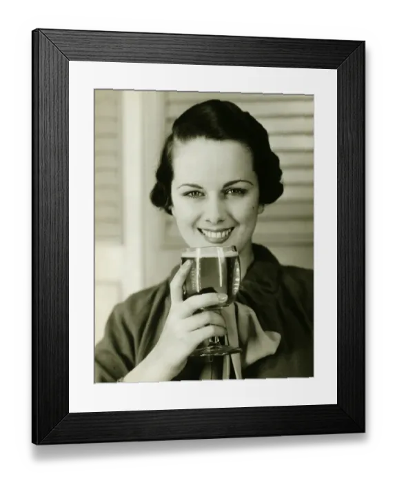 Framed Print : Young woman holding glass of beer, (B&W), portrait Framed Print : Young woman holding glass of beer, (B&W), portrait
