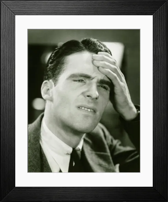 Framed Print : Young businessman with headache, (B&W), close-up Framed Print : Young businessman with headache, (B&W), close-up