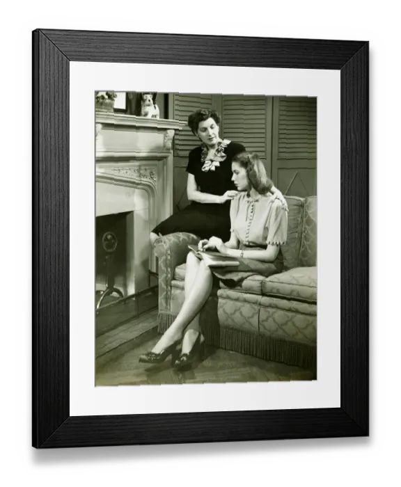 Framed Print : Two women sitting on couch, discussing, (B&W) Framed Print : Two women sitting on couch, discussing, (B&W)